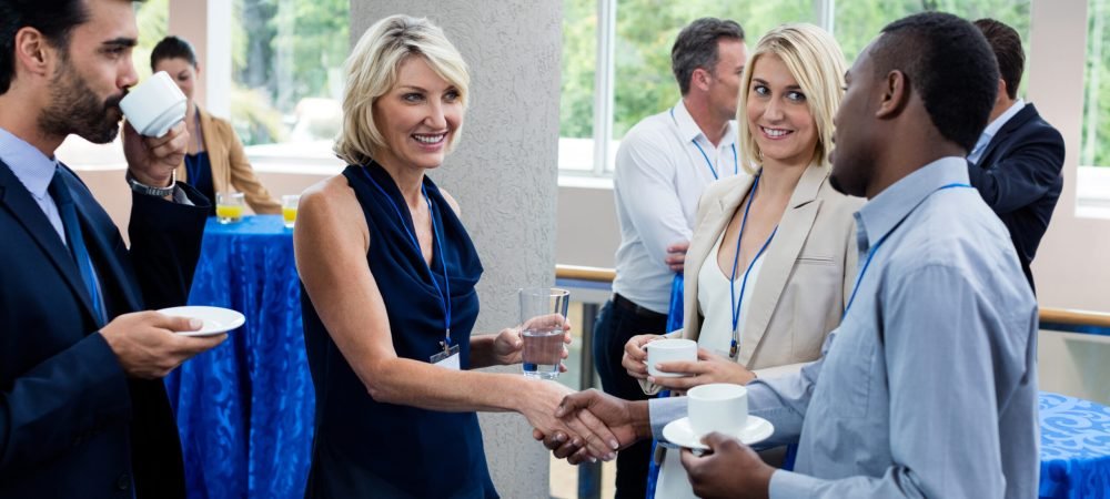 Business executives interacting with each other while having coffee Business executives interacting with each other while having coffee at conference center