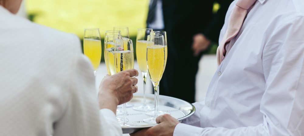 waiter-dressed-white-carries-glasses-with-champagne